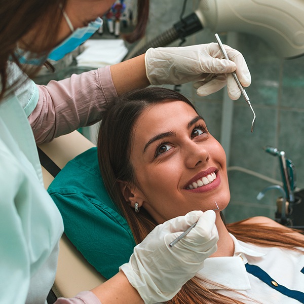 Woman smiling at dental team member