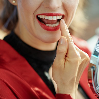 Woman in red pointing to her tooth