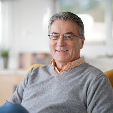 Man in a grey shirt relaxing on a couch