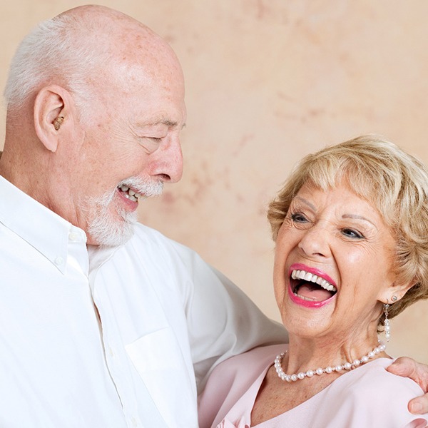 Older couple with dentures in Hingham smiling and laughing