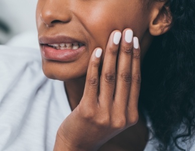 Closeup of person with toothache holding cheek