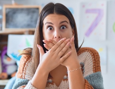 Woman with knocked out tooth covering her mouth