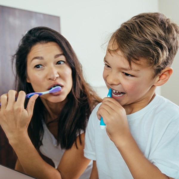 Mother and child brushing teeth to prevent dental emergencies