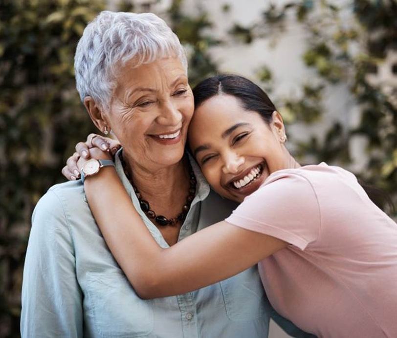 a woman with implant dentures smiling with her granddaughter