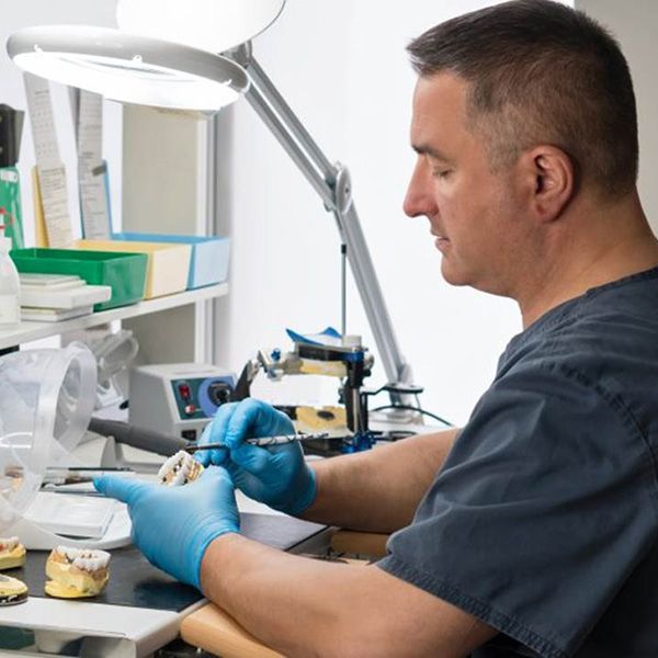 a dental technician creating implant dentures in Hingham