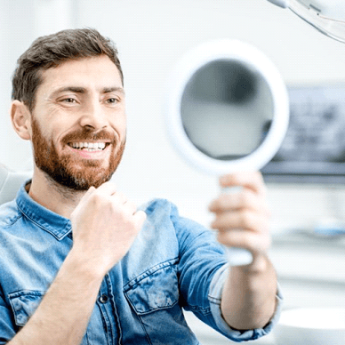 man seeing his new smile with dental implants