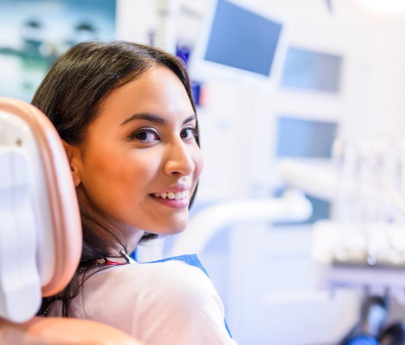 Woman smiling and waiting in a dental chair