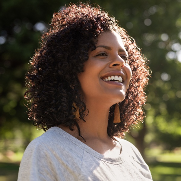 Woman sharing flawless smile thanks to dental implant tooth replacement