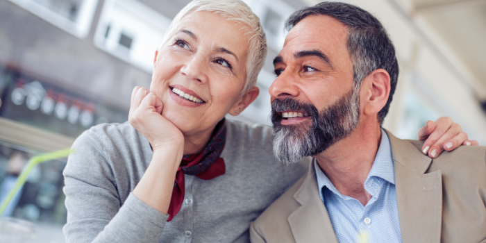 Man and woman smiling after replacing missing teeth