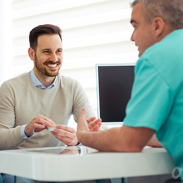 Dental team member and dentistry patient discussing out dental insurance works