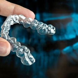 person holding an Invisalign aligner in their hand