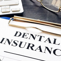 dental insurance form on a blue clipboard