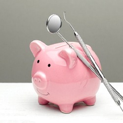 dental instruments resting on a pink piggy bank