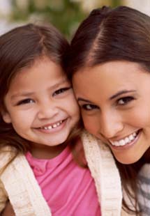 A woman and her daughter smiling after visiting the children's dentist near Weymouth