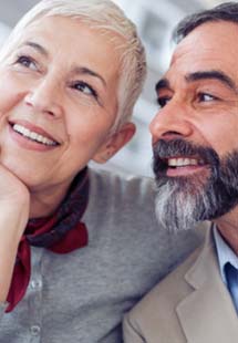 A man and woman thinking about options for replacing missing teeth near Weymouth