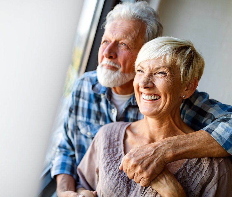 Man and woman with healthy smiles after gum disease treatment