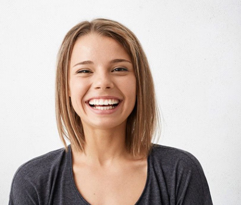 young woman smiling after getting teeth whitening in Hingham