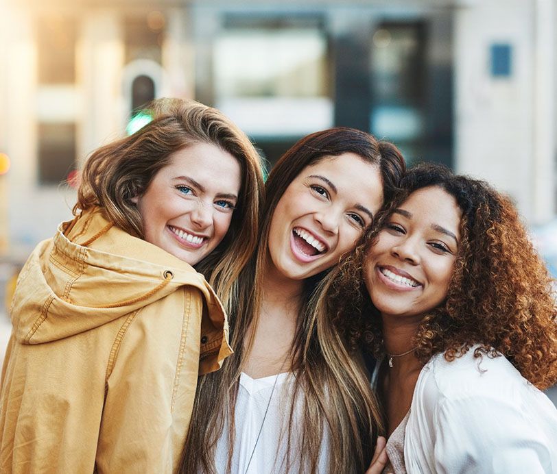 Three friends smiling with veneers in Hingham