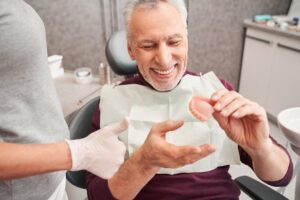 Man smiling after getting his dentures relined by his dentist